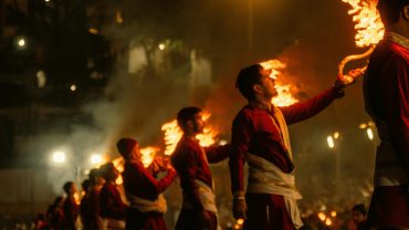 Captivating Ganga Aarti ceremony in Rishikesh, India with priests holding flaming torches.