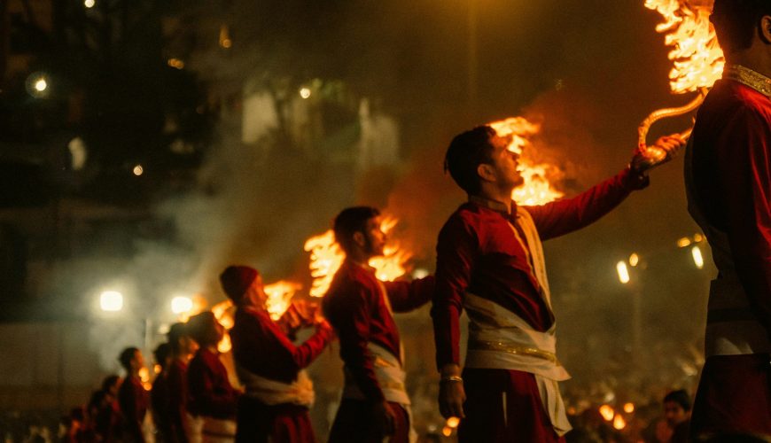 Captivating Ganga Aarti ceremony in Rishikesh, India with priests holding flaming torches.