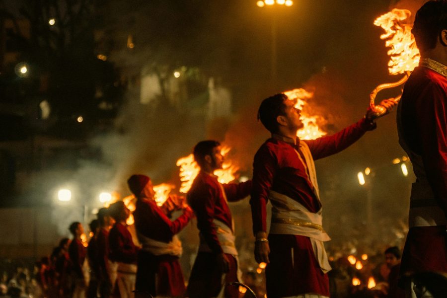 Captivating Ganga Aarti ceremony in Rishikesh, India with priests holding flaming torches.